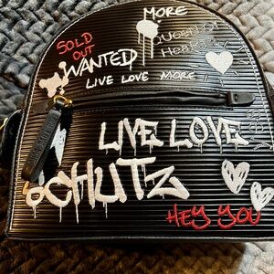 SCHUTZ Black Textured Backpack with Red, White & Black Details.